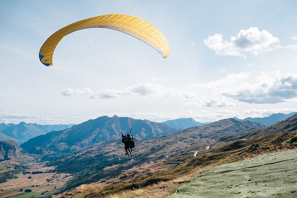 A paraglider over a mountain valley