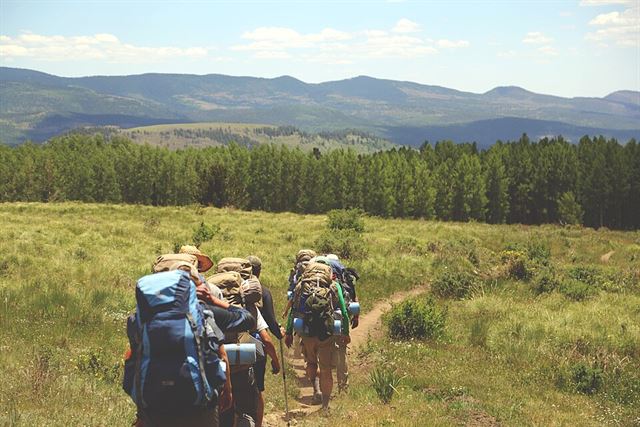 A group of backpackers on a trail through the hills
