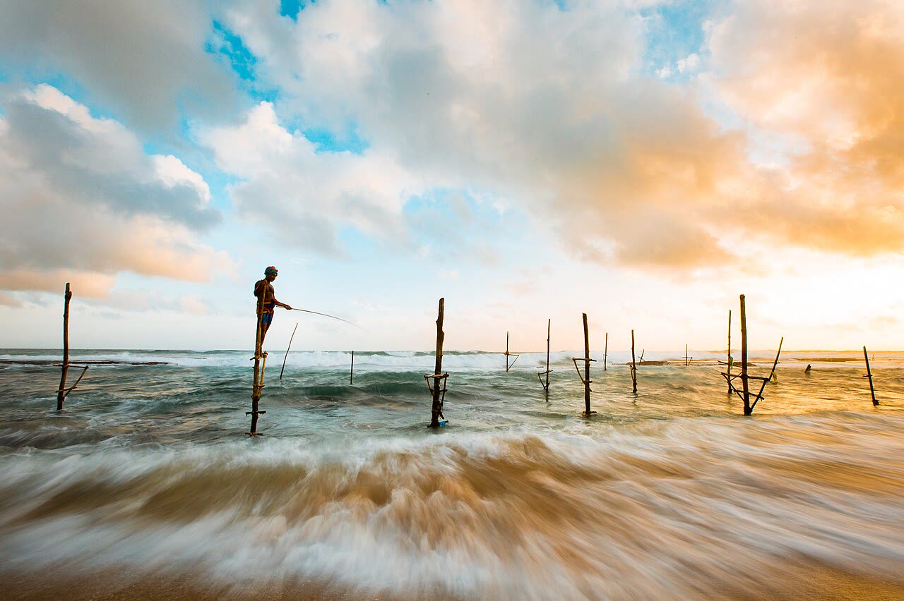 Stilt fishermen in the surf at Hikkaduwa, Sri Lanka