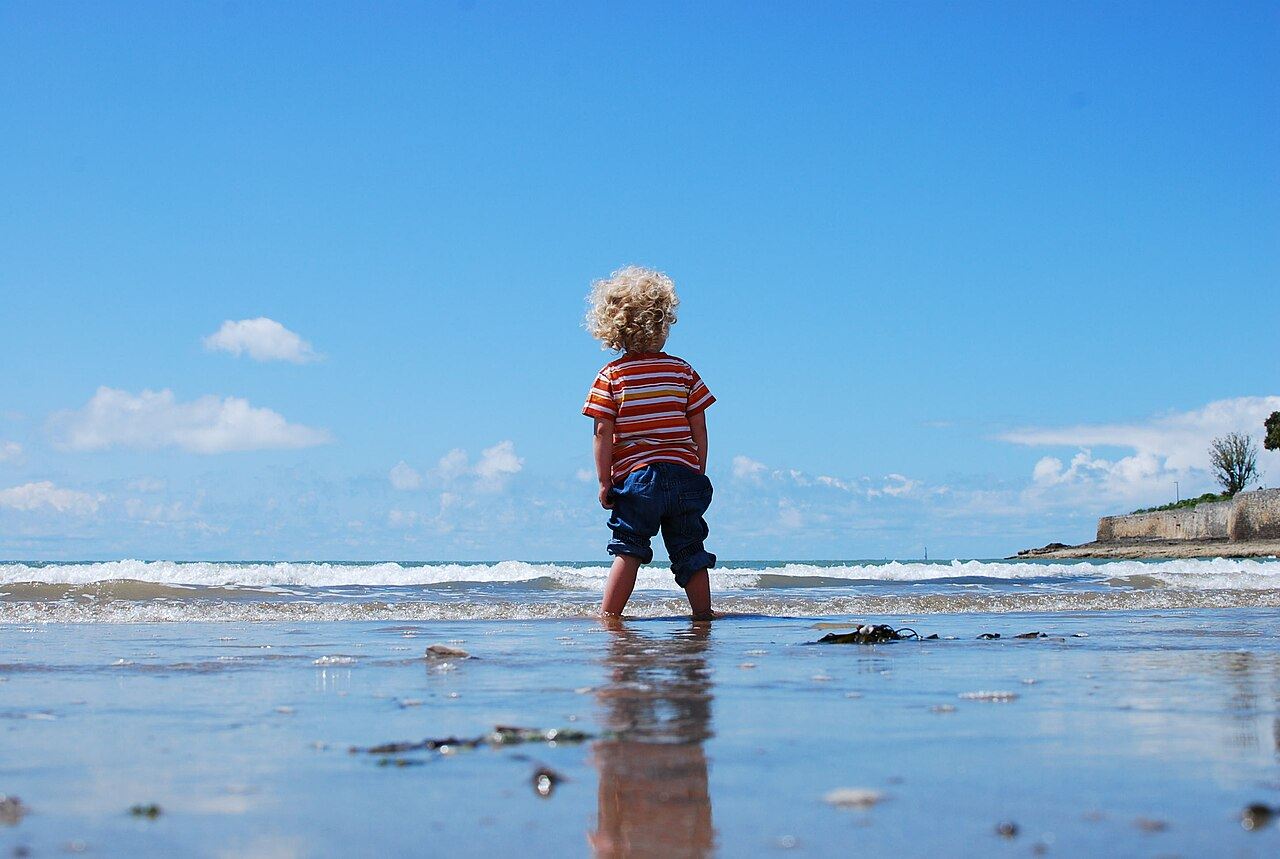 A little boy standing in the sea