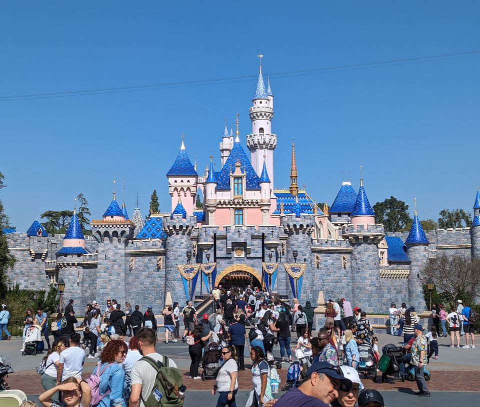 Families in front of a fairy-tale castle at a theme park