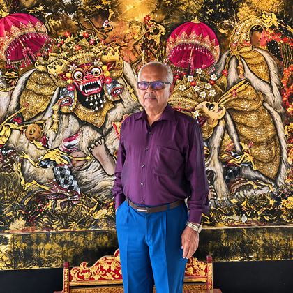 Our traveller in front of a painted Barong mural in Bali