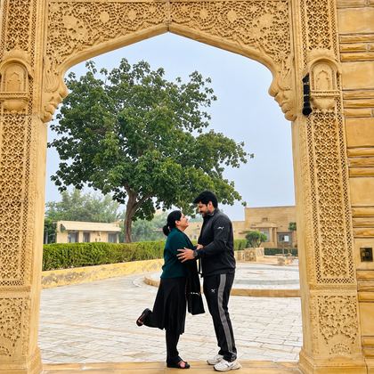 Two of our travellers under a carved sandstone arch in Rajasthan