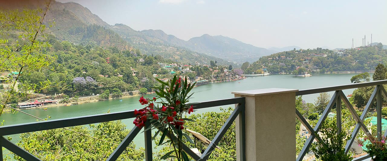 A balcony above a hill lake, flowers on the rail