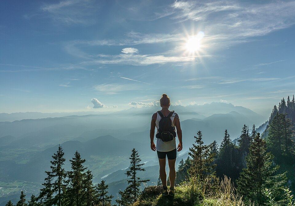 A hiker looking out over forested mountains